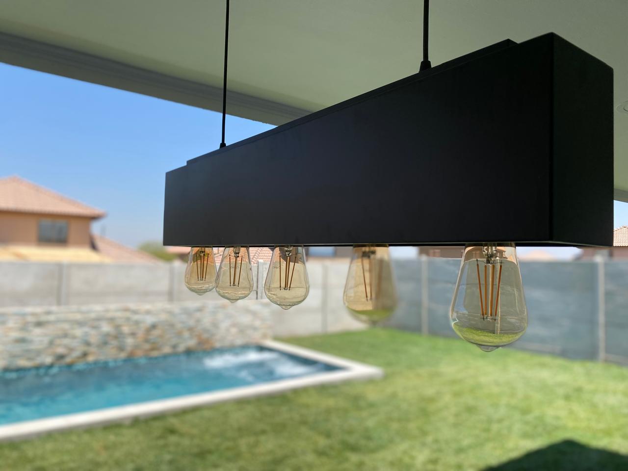 Lámpara del quincho con la piscina al fondo